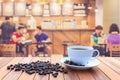 White coffee cup and coffee beans on wood table with blurred bac Royalty Free Stock Photo