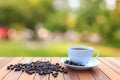 White coffee cup and coffee beans on wood table with blurred bac Royalty Free Stock Photo