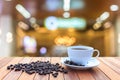 White coffee cup and coffee beans on wood table with blurred bac Royalty Free Stock Photo