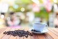 White coffee cup and coffee beans on wood table with blurred bac Royalty Free Stock Photo