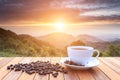 White coffee cup and coffee beans on wood table and view of suns Royalty Free Stock Photo