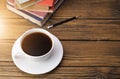White coffee cup with dark black coffee and old books were Put on an old wooden table And soft sunlight shone into the warm Royalty Free Stock Photo