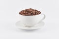 White coffee cup filled with whole coffee beans Royalty Free Stock Photo