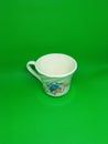 White coffee cup floral print on green background Royalty Free Stock Photo