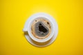 White coffee Cup with foam saucer on a bright yellow background top view Royalty Free Stock Photo