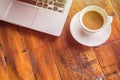 White coffee cup and laptop on wooden table top view