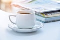 white coffee cup in morning with newspaper and book on table. Royalty Free Stock Photo