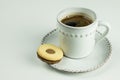 A white cup of black coffee and cooky on white background.