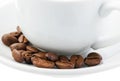 White coffee cup on saucer and roasted beans isolated on white background. Selective focus. Close up Royalty Free Stock Photo