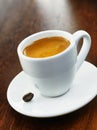 White coffee cup and saucer with single bean Royalty Free Stock Photo