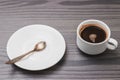 White coffee cup, saucer and spoon separately on grey wooden background in office table, minimalist flat lay style with hot Royalty Free Stock Photo