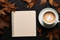 A white coffee cup sits on a table with a spiral notebook Royalty Free Stock Photo