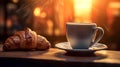 A white coffee cup sits on a white plate next to a croissant Royalty Free Stock Photo