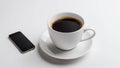 White coffee cup with smartphone on table, modern work setting Royalty Free Stock Photo