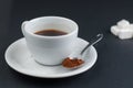 White coffee cup with sugar cubes isolated on a black background