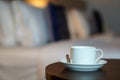 White coffee cup on the table by a sofa couch in hotel room Royalty Free Stock Photo