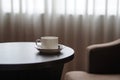 White coffee cup on the table by a sofa couch in hotel room Royalty Free Stock Photo