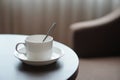 White coffee cup on the table by a sofa couch in hotel room Royalty Free Stock Photo