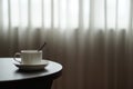 White coffee cup on the table by a sofa couch in hotel room Royalty Free Stock Photo