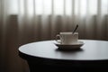 White coffee cup on the table by a sofa couch in hotel room Royalty Free Stock Photo