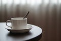 White coffee cup on the table by a sofa couch in hotel room Royalty Free Stock Photo