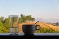 White coffee cup and water glass in morning with mountain view, thailand Royalty Free Stock Photo