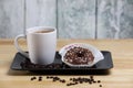 White coffee cup on a wooden table with chocolate and white chocolate donuts . Morning espresso. Morning cappuccino mug. Royalty Free Stock Photo