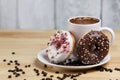 White coffee cup on a wooden table with chocolate and white chocolate donuts . Morning espresso. Morning cappuccino mug. Royalty Free Stock Photo