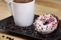 White coffee cup on a wooden table with chocolate and white chocolate donuts . Morning espresso. Morning cappuccino mug. Royalty Free Stock Photo