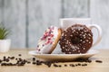 White coffee cup on a wooden table with chocolate and white chocolate donuts . Morning espresso. Morning cappuccino mug. Royalty Free Stock Photo