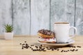 White coffee cup on a wooden table with chocolate and white chocolate donuts . Morning espresso. Morning cappuccino mug. Royalty Free Stock Photo