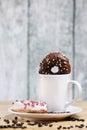 White coffee cup on a wooden table with chocolate and white chocolate donuts . Morning espresso. Morning cappuccino mug. Royalty Free Stock Photo