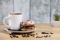 White coffee cup on a wooden table with chocolate and white chocolate donuts . Morning espresso. Morning cappuccino mug. Royalty Free Stock Photo