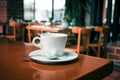 White coffee cup on wooden table in coffee shop blur background Royalty Free Stock Photo