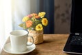 Working from home set up. Laptop computer and coffee cup on a table by the window. Royalty Free Stock Photo