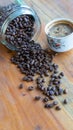 White coffee cups and coffee beans that spill around with wooden table backgrounds