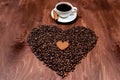White coffee mug, gingerbread and coffee bean heart on a wooden texture board Royalty Free Stock Photo