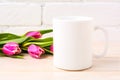 White coffee mug mockup with magenta pink tulips bouquet Royalty Free Stock Photo