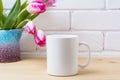 White coffee mug mockup with pink tulip in purple blue vase Royalty Free Stock Photo