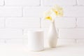 White coffee mug mockup with soft yellow orchid in vase Royalty Free Stock Photo