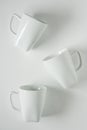 3 white coffee mugs on white background scattered with empty copy space Royalty Free Stock Photo