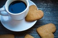 White coffeecup with hot fresh beverage and heart-shaped gingerbread biscuits. Coffee break with love. Side of coffee