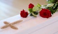 A white coffin with red roses and a sand cross after blessing Royalty Free Stock Photo