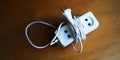 White coiled extension cord casts shadow on table closeup