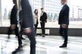White collar workers going down office corridor during working day. Royalty Free Stock Photo