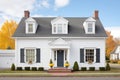 white colonial with black shutters and dormer windows