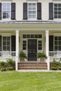 White colonial house, porch and plants