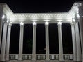 White colonnade in the dark. White columns in the light of spotlights. Element of the architectural ensemble in the city park