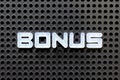 White alphabet with word bonus on black pegboard background Royalty Free Stock Photo
