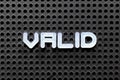 White alphabet with word valid on black pegboard background Royalty Free Stock Photo